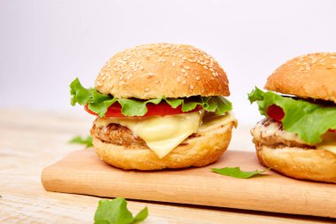 Işık arka planda ahşap masada zanaat sığır Burger. Sokak Yemeği, Fast Food. Peynir ve ahşap masada ev yapımı sulu hamburgerler. Boşluk Kopyala.