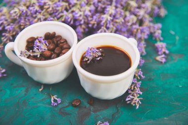 Kahve, fincan kahve taneleri ve yukarıdan yeşil arka plan üzerinde lavanta çiçeği. Günaydın konsepti. Kadın çalışma masası. Rahat kahvaltı. Mockup. Düz döşeme stili