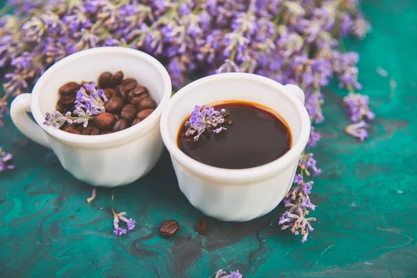 Kahve, fincan kahve taneleri ve yukarıdan yeşil arka plan üzerinde lavanta çiçeği. Günaydın konsepti. Kadın çalışma masası. Rahat kahvaltı. Mockup. Düz döşeme stili