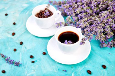 Yukarıdan mavi arka plan üzerinde kahve ve lavanta çiçeği. Günaydın konsepti. Kadın çalışma masası. Rahat kahvaltı. Mockup. Düz döşeme stili