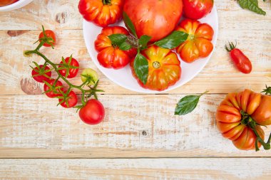 Domates arka plan karışımı. Beyaz ahşap masa arka planda güzel sulu organik kırmızı domates. Temiz yemek konsepti. Kopya alanı, düz yatıyordu