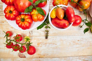 Domates arka plan karışımı. Beyaz ahşap masa arka planda güzel sulu organik kırmızı domates. Temiz yemek konsepti. Kopya alanı, düz yatıyordu