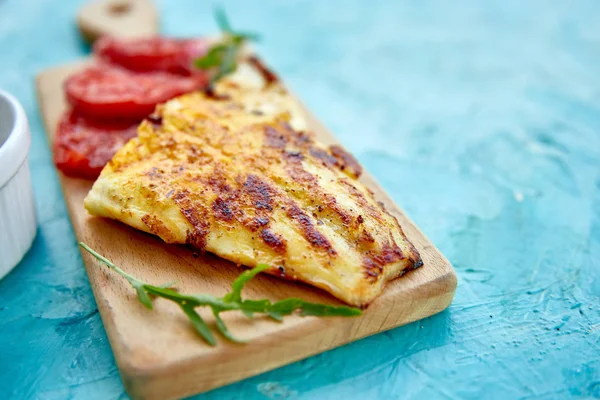 Ahşap tahta üzerinde domates ile ızgara pike fileto