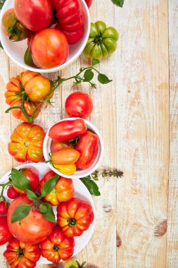 Domates arka plan karışımı. Beyaz ahşap masa arka planda güzel sulu organik kırmızı domates. Temiz yemek konsepti. Kopya alanı, düz yatıyordu