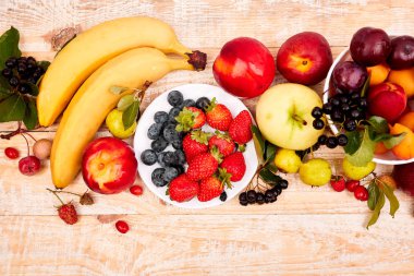 Beyaz ahşap arka plan, üst görünüm üzerinde meyve düz yatıyordu. Vejetaryen, Vegan, diyet, temiz yeme, kilo kaybı malzemeleri. Yaz meyve gıda arka plan. Boşluk Kopyala.