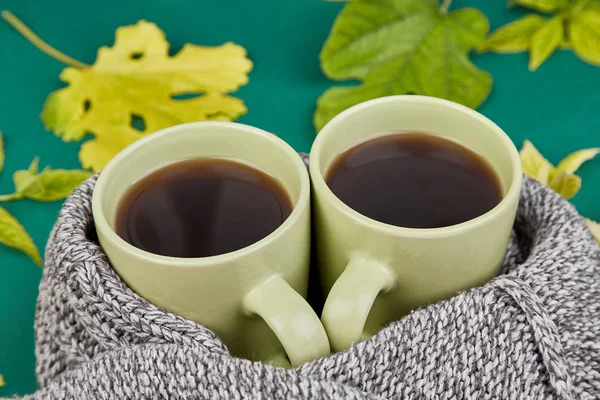 Knitted Scarf Two Warm Cups Tea Autumn Leaves Green Background — Stock Photo, Image