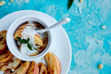 Mavi arka planda beyaz tabakta dondurma lı ızgara şeftali. Izgara tatlı. Barbekü meyvesi. Kopya alanı. Sağlıklı yiyecekler. Vegan gıda.