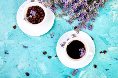 Yukarıdan mavi arka plan üzerinde kahve ve lavanta çiçeği. Günaydın konsepti. Kadın çalışma masası. Rahat kahvaltı. Mockup. Düz döşeme stili