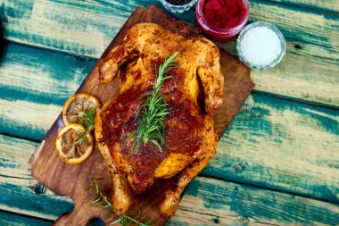 Ahşap yeşil arka plan üzerinde ahşap tahta üzerinde soslar ile Pişmiş bütün tavuk. Noel tavuğu. Akşam yemeği. Meze