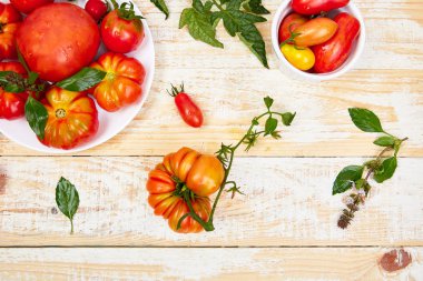 Domates arka plan karışımı. Beyaz ahşap masa arka planda güzel sulu organik kırmızı domates. Temiz yemek konsepti. Kopya alanı, düz yatıyordu