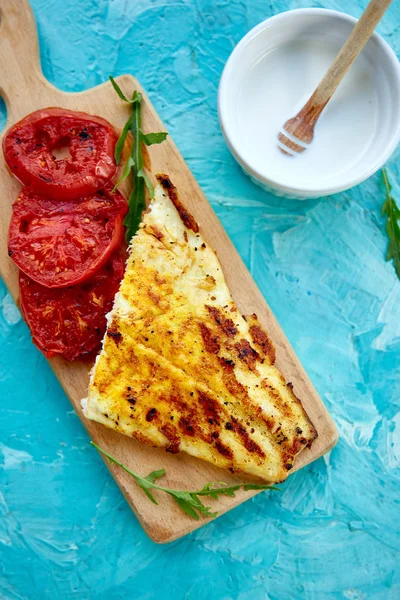 Mavi arka plan üzerinde ahşap tahta üzerinde domates ile ızgara pike fileto. Izgara deniz ürünleri. Barbekü balığı. Kopya alanı. Sağlıklı gıda.