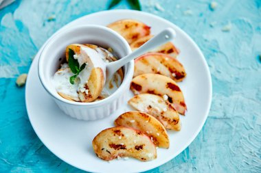 Mavi arka planda beyaz tabakta dondurma lı ızgara şeftali. Izgara tatlı. Barbekü meyvesi. Kopya alanı. Sağlıklı yiyecekler. Vegan gıda.