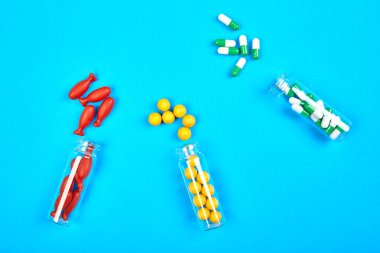 Mavi arka planda cam kavanozdaki Coklor haplarının üzerinde dizaynınız için fotokopi alanı vardı. Sağlık hizmeti konsepti. Tıbbi günlük için minimalizm biçimi şablonu