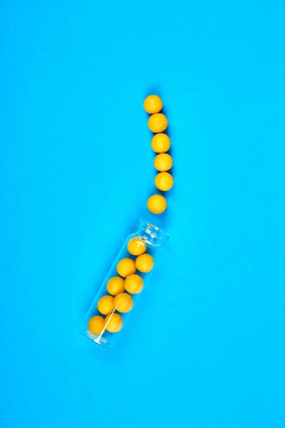 フラットは あなたのデザインのためのコピースペースと青い背景にガラス瓶に黄色の丸薬のオーバーヘッドを置きます ヘルスケアの概念 医療ブログのためのミニマリズムスタイルテンプレート — ストック写真
