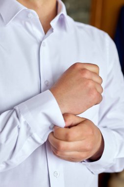 Yakışıklı damat giyiniyor ve düğüne hazırlanıyor. Zarif genç moda adam düğün kutlaması için giyinme.