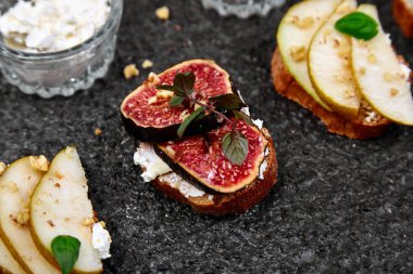 Armut, ricotta peyniri, bal, incir, fındık ve şifalı otla Kahvaltı tostları ya da atıştırmalık sandviçler. Antipasto. İtalyan yemeği. Üst Manzara. Boşluğu kopyala.