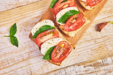 Domatesli bruschetta, mozzarella peyniri ve fesleğen.