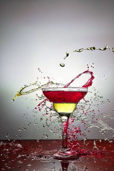 Склянка з синьо-жовтим шампанським або коктейлем. Левітація — стокове фото