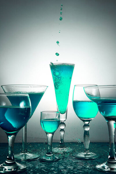 Много бокалов с голубым шампанским или коктейлем
.