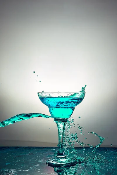 Glass with blue champagne or cocktail. Levitation