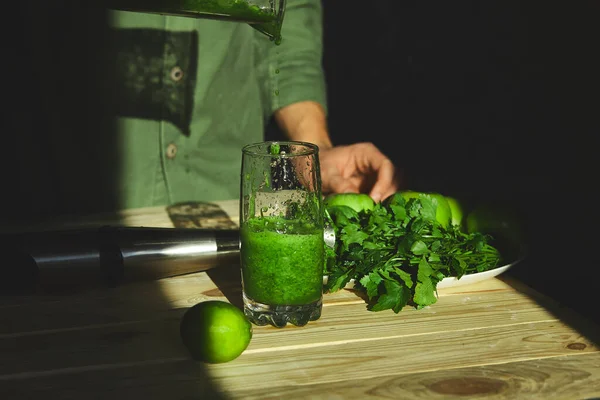 男人倒入玻璃杯健康排毒冰沙 用搅拌机烹调 在家里用新鲜水果和绿色菠菜 生活方式排毒的概念 生活方式排毒的概念 冰岛人喝酒 — 图库照片