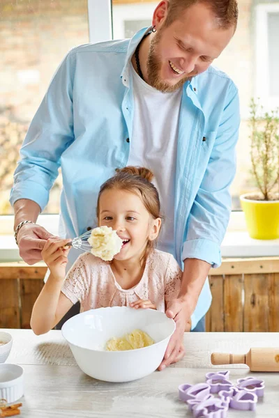 Father and daughter preparing dough together in kitchen, Family cooking at home, fatherhood and family weekend concept.