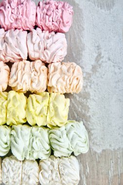 Ev yapımı tatlı marşmelov, çok renkli pastel zephyr arkaplanı, üst manzara, fotokopi alanı. Düz yatıyordu.