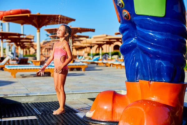 Engraçado menina em maiô refrigeração no chuveiro fora — Fotografia de Stock