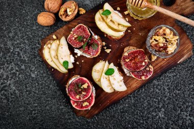 Armut, ricotta peyniri, bal, incir, fındık ve şifalı otla Kahvaltı tostları ya da atıştırmalık sandviçler. Antipasto. İtalyan yemeği. Üst Manzara. Boşluğu kopyala.