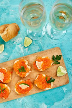 Kasede somon kırmızısı havyar ve tahta kesme tahtasıyla sandviç.