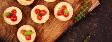 Tahta üzerinde mozzarella peyniri olan vişneli domatesli Mini turtalar. Üst Manzara. Boşluğu kopyala.