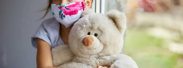 Kleines Mädchen Kind Maske Mit Teddybär Sitzt Fenster Coronavirus Quarantäne — Stockfoto