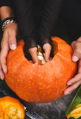 Kız ve baba elleri Cadılar Bayramı için oymadan önce kabaktan tohum ve lifli malzeme çıkarır, Jack O 'Lantern' i hazırlar. Küçük aile yardımcısı, Üst Manzara, kapat, Yukarıdan görüntüle, boşluğu kopyala