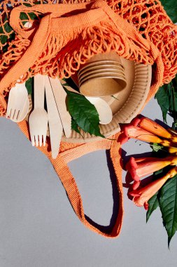 Çevre sanatı kağıdı ve ahşap sofra takımı, sert ışık, sıfır atık, plastiksiz ve çevre dostu yaşam, kağıt bardaklar, çanaklar, tabaklar ve pamuk ağdaki ahşap çatal bıçak takımı, geri dönüşüm veya çevre dostu kavram.