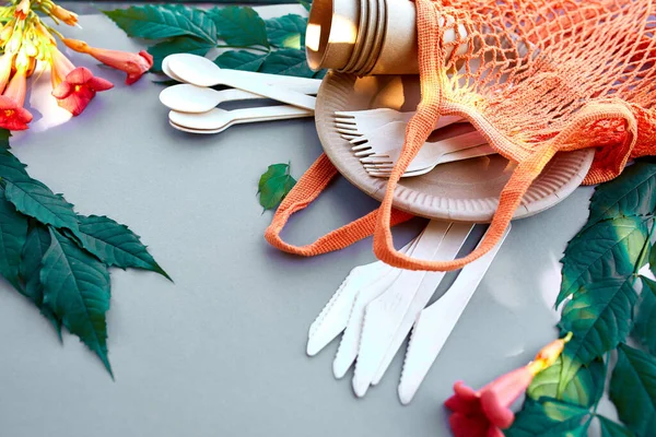 Çevre sanatı kağıdı ve ahşap sofra takımı, sıfır atık, plastiksiz ve çevre dostu yaşam, kağıt bardaklar, çanaklar, çantalar, tabaklar ve pamuk ağdaki ahşap çatal bıçak takımı, geri dönüşüm veya çevre dostu konsept.