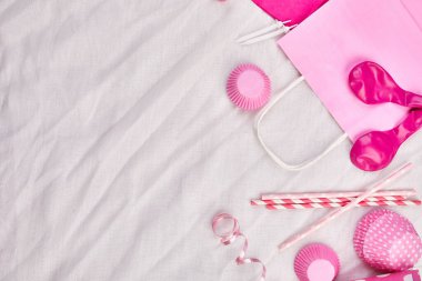 Doğum günü kızı yatağı, üst görünüm ve pembe festival öğeleri, parti şapkaları ve flamaları, doğum günü veya parti tebrik kartı içeren arkaplan, çerçeve veya arkaplan kopyalama alanı.