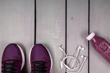 Tepeden bakan kadın kıyafetleri, kadın spor malzemeleri, gri ahşap arka planda pembe spor, üstten manzara, düz yatış.