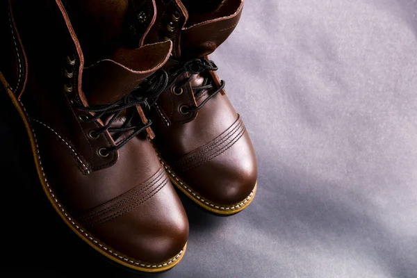 Yüksek çizmeler. Açık siyah arka planda şık erkek deri kahverengi ayakkabıları. Üst Manzara. Boşluğu kopyala.