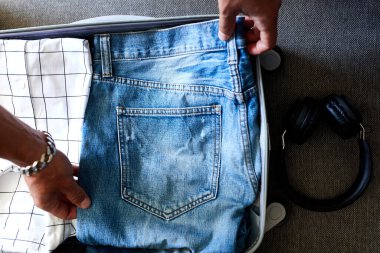 Tanınmayan bir adamın elleri günlük kotunu, seyahat, seyahat, tatil için bavulunda gömleklerini topluyor. Boşluğu kopyala.