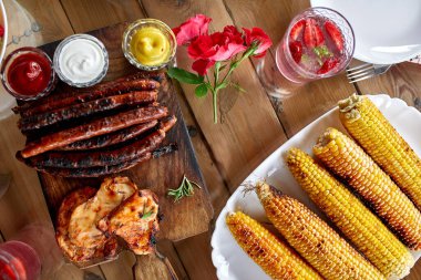 Et ızgaralı yemek masası, kızarmış sebzeler, soslar ve limonata. Parti masasında servis edilen aperatifler..