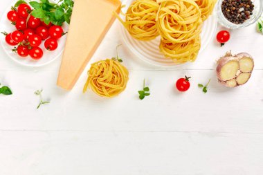 Makarna pişirmek için gerekli malzemeler - tagliatelle, domates, sarımsak, fesleğen, parmesan peyniri beyaz ahşap arka plan düzlüğü, üst görünüm, çerçeve, kopyalama alanı, İtalyan gıda kavramı.