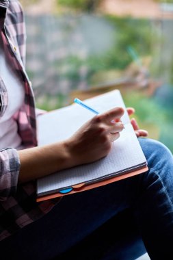 Kadın, pencerede oturuyor, defter hedefleri yazıyor, plan yapıyor, liste yapıyor, kitap yazıyor, kız günlüğe notlar yazıyor, planlar yazıyor, gazetecilik makale yazıyor, öğrenci seminere hazırlanıyor, yaşam tarzı....