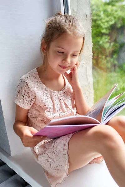 Nettes Kleines Mädchen Liest Buch Hause Auf Der Fensterbank Kind — Stockfoto