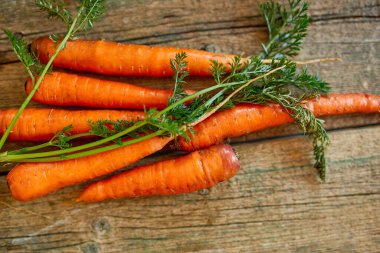 Tahta arka planda kökleri olan taze havuç, biyolojik sağlıklı arka planda organik gıda, köy pazarı tarzı, bahçe ürünü, diyet vejetaryen yemeği, temiz yemek..