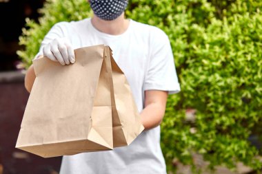 Courierin White ambarda yiyecek, teslimat servisi, restoranların yemek teslimatı. Coronavirus COVID-19 salgınından korunmak için evde kal. Bağlantısız teslimat servisi karantina altında.