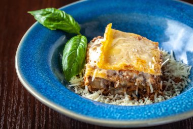 İtalyan lazanya kıyma bolognese, havuç ve Parmesan peyniri güzel bir seramik mavi plaka ile. Kopya alanı, seçici odak