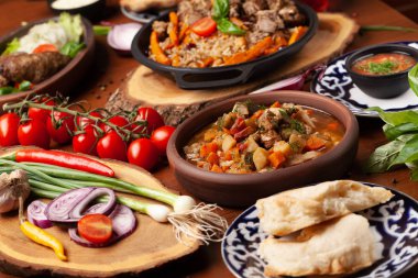 Geleneksel özbek Doğu mutfağı. Özbek yeni yıl tatili için farklı yemekler aile tablosundan. Arka plan resmi üst görülmektedir.