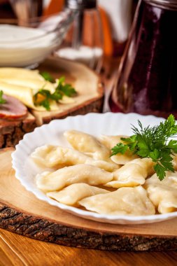 Ukraynalı mutfağı, vareniki patates, ekşi krema masanın üzerinde beyaz bir plaka ile ile kavramı. restoranda kahvaltı. Kopya alanı, seçici odak