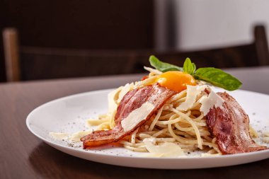 Kızarmış domuz pastırması ile İtalyan makarna spagetti carbonara parmesan peynir ve yumurta sarısı. Restoran tabloda bu. Kopya alanı, seçici odak