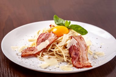 Kızarmış domuz pastırması ile İtalyan makarna spagetti carbonara parmesan peynir ve yumurta sarısı. Restoran tabloda bu. Kopya alanı, seçici odak